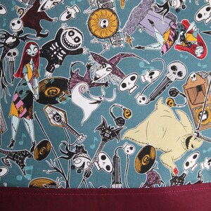 Może przedstawiać: Tkanina w kolorze turkusowym z powtarzającym się wzorem postaci z filmu Koszmar przed świętami. Postacie to Jack Skellington, Sally i Zero. Tkanina idealnie nadaje się do projekt&oacute;w rękodzielniczych, takich jak torby, poduszki i kołdry.