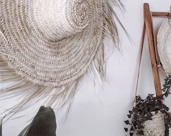 Väggdekoration med stråhatt tillverkad av naturfiber. Traditionell marockansk hatt, boho etnisk stil.