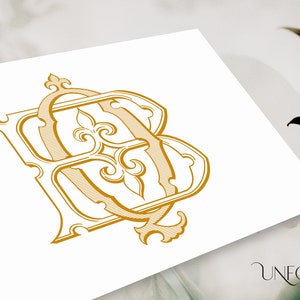 May include: A gold-colored monogram design featuring the intertwined letters "B" and "A" in an ornate, vintage style. The design includes decorative flourishes and is set against a white background. The logo for "Unfold Studio" is in the bottom right corner.