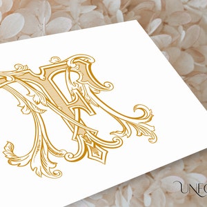 Op de afbeelding: Een gouden monogram met de letters "A" en "R" die in elkaar zijn verweven. De letters worden omringd door sierlijke bloemmotieven.