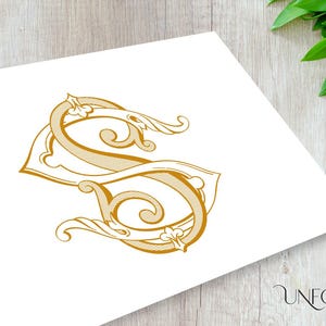 May include: A gold-colored monogram with the letter "S" in a decorative, ornate font. The letter is stylized with intricate flourishes and swirls.