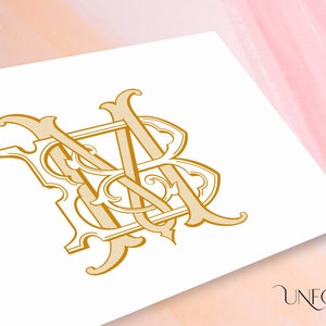 May include: A gold monogram with the letters "MB" intertwined in a decorative, ornate style. The letters are stylized with flourishes and swirls.