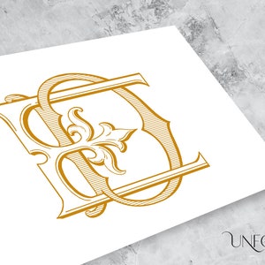 May include: Gold-colored monogram design featuring the letters "S" and "D" intertwined with ornate floral elements. The design is printed on a white surface. The lower right corner displays the text "UNFOLD STUDIO".