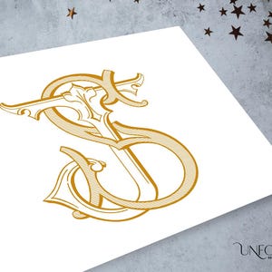 May include: A gold-colored monogram featuring the intertwined letters S and J in a decorative, calligraphic script style with fine line detailing. The design is printed on a white surface, with the text Unfold Monograms visible in the corner.