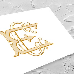 Peut inclure: Un monogramme doré avec les lettres "KE" entrelacées dans une police décorative et ornée.