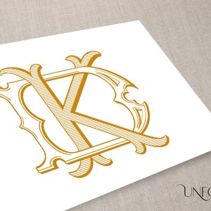 Pode incluir: Um monograma dourado com as letras "K" e "D" entrelaçadas em um design decorativo e ornamentado.