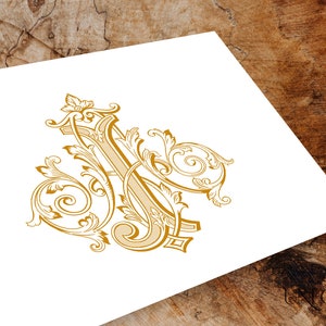 May include: A gold-colored monogram with ornate flourishes and swirls, forming the letters "J" and "A".