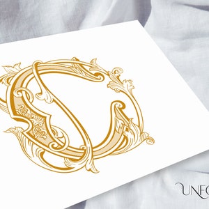 Puede incluir: Una letra O decorativa dorada adornada con un diseño floral.
