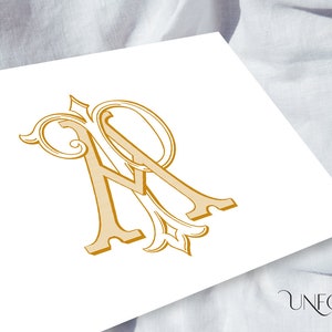 May include: A gold monogram with the letters "AR" intertwined in a decorative script font.
