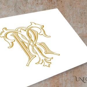 May include: Gold-coloured intertwined monogram design on a white background. The elegant, ornate letters are stylized with flourishes and decorative elements. The image is set against a neutral, textured backdrop. The Unfold Studio logo is in the bottom right corner.