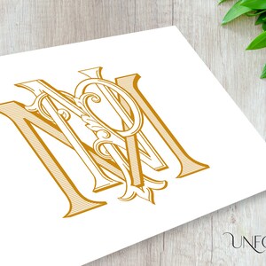 以下が含まれることがあります： 「M」と「M」の文字が絡み合った、金色のモノグラム。文字は装飾的な花飾りでスタイリッシュにデザインされています。