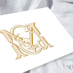 Könnte beinhalten: Ein goldfarbenes Monogramm-Design mit den verschlungenen Buchstaben "M" und "A" in einem verzierten, Vintage-Stil. Das Design enthält dekorative Verzierungen und ist auf einer weißen Oberfläche gedruckt. Das Logo "Unfold Studio" befindet sich unten rechts.