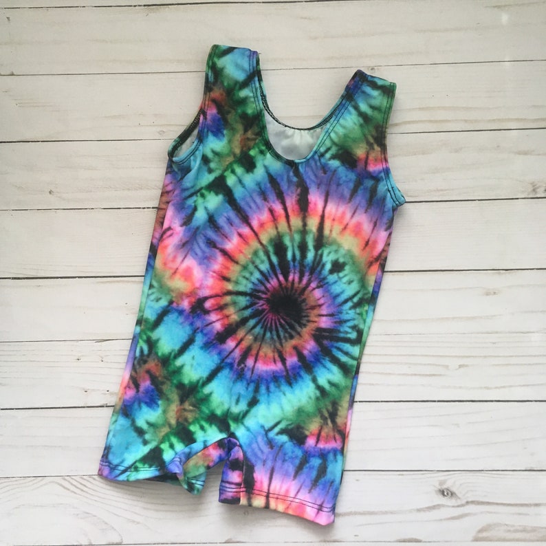 K&ouml;nnte beinhalten: Ein tie-dye &auml;rmelloser Einteiler mit einem bunten Wirbelmuster in Blaut&ouml;nen, Rosa, Gr&uuml;n und Schwarz.