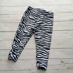 Black and white zebra print leggings for infant, toddler or child. Fold over elastic band waste and to ankle length. Made of athletic stretch fabric for a second skin fit.