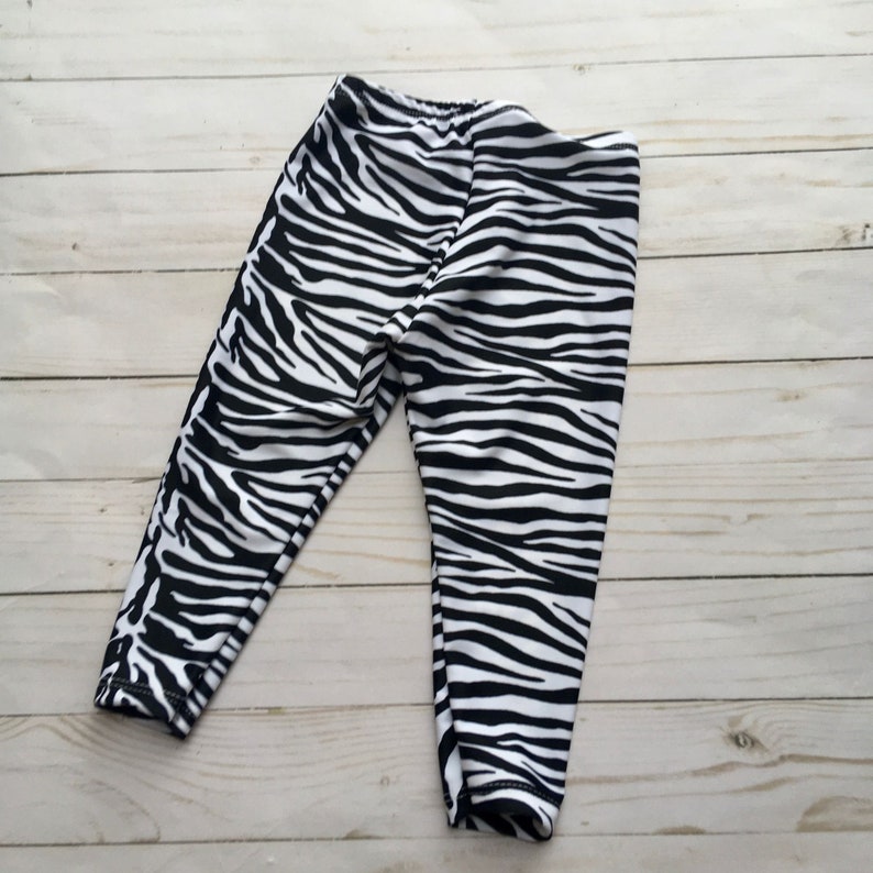 Black and white zebra print leggings for infant, toddler or child. Fold over elastic band waste and to ankle length. Made of athletic stretch fabric for a second skin fit.