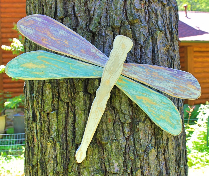 Buy some large wooden dragonflies to mount on your fence--or try to make your own! Paint them or mix and match sizes and styles to get fun and unique dragonflies. Here are some quick and easy ways to decorate your garden fence.  