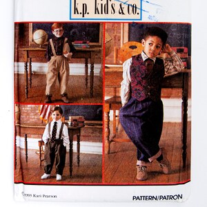 May include: Simplicity pattern for children's clothing, featuring three boys in different outfits. The pattern includes a vest, suspenders, and trousers. The text "k.p. kid's & co." is visible. The pattern size is AA (3-6).