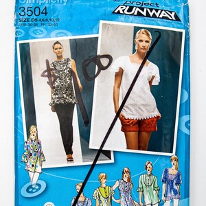 May include: A blue Simplicity sewing pattern envelope, with images of women's tops and a dress. The envelope has the text "Simplicity 3504" and "Project Runway." The pattern includes sizes 4, 6, 8, 10, and 12.