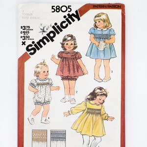 Può includere: Un cartamodello per cucire abiti smock per bambini piccoli. Il cartamodello include quattro stili di abiti diversi: un abito blu con colletto bianco, un abito a quadri rossi e bianchi, un abito bianco con pois blu e un abito giallo. Il cartamodello include anche istruzioni per fare lo smock sugli abiti.