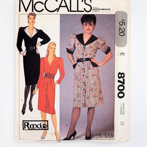 Peut inclure: Un patron de couture pour une robe à imprimé floral et une ceinture noire. Le patron est de McCall's et est de taille 12. Le numéro du patron est 8700.