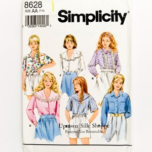 May include: A vintage Simplicity sewing pattern packet showing illustrations of women's blouses and shorts. The packet includes the number 8628 and the text "Uptown Silk Shoppe". The pattern is for sizes AA (7-10).