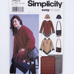 May include: Simplicity sewing pattern 5465 for sizes XS, S, M. The envelope features illustrations of a fringed poncho, a hooded top, two shoulder bags, two hats, and fabric swatches. A model wears the red fringed poncho and a shoulder bag.