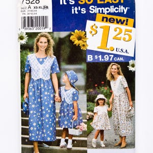 Op de afbeelding: Een vintage naaipatroon getiteld "It's SO EASY it's Simplicity" met een blauw en wit bloemenjurk ontwerp. Het patroon bevat maten XS-XL en toont een moeder en dochter die de jurken dragen. De prijs is $1,25.