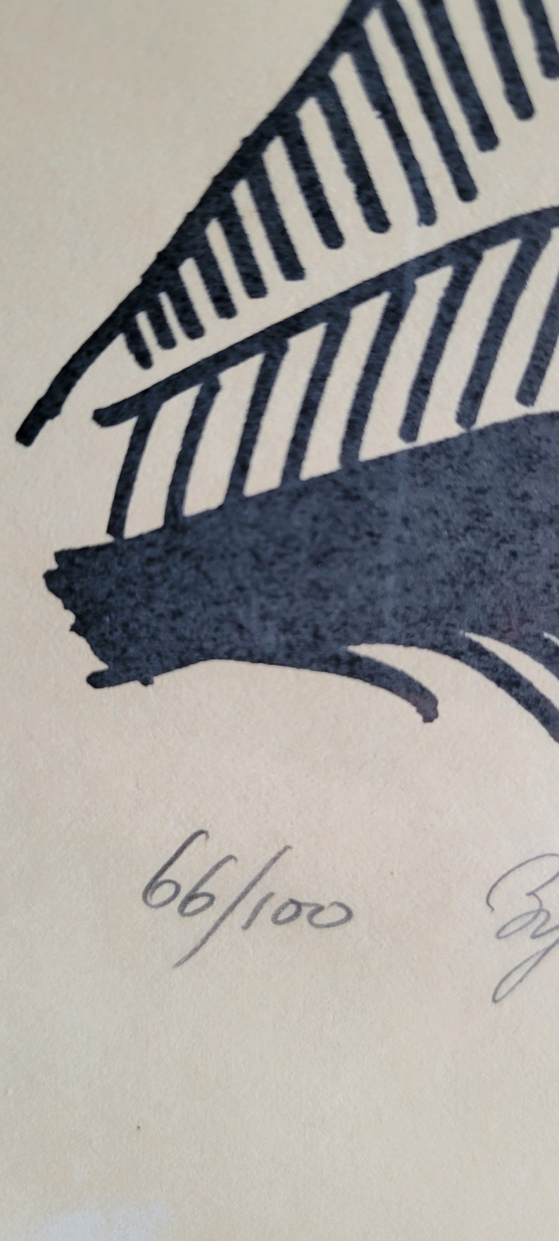 May include: Abstract art print featuring a dark blue, stylized feather design against a cream background. The print is numbered 66/100, indicating a limited edition. The artwork has a minimalist aesthetic.