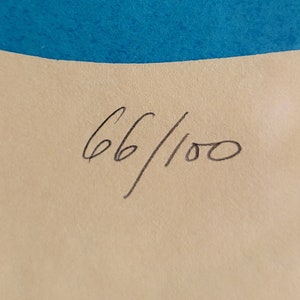May include: Artwork print with blue and white horizontal stripes at the top. The print is numbered 66/100 in black ink on a beige background. The artwork has a minimalist design.