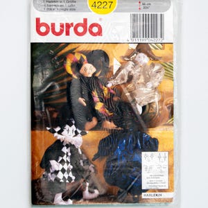 May include: A Burda sewing pattern envelope for a 23-inch harlequin doll, model 4227. The packaging features illustrations of four harlequin dolls in various costumes, including black and white checkered patterns and metallic fabrics.