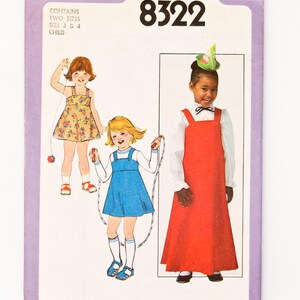 May include: Simplicity pattern 8322 for children's clothing. The cover shows illustrations of three young girls in dresses and jumpers. The pattern includes two sizes, sizes 3 and 4. The cover is purple with the Simplicity logo and price.