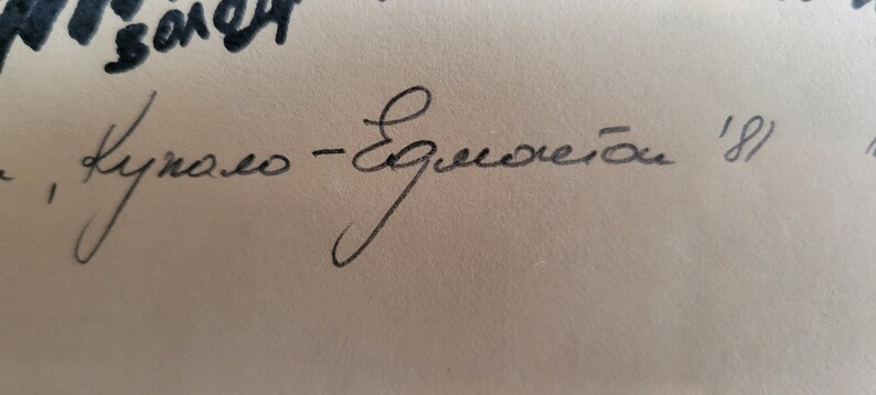 May include: Close-up of handwritten text in black ink on a beige background. The text includes the words "Kyпaлo - Eдмостой" and the number "'81". The handwriting is cursive.