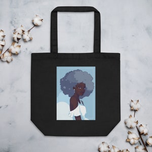 May include: Black tote bag with a white design of a woman with blue hair and a white dress. The woman is looking to the right.