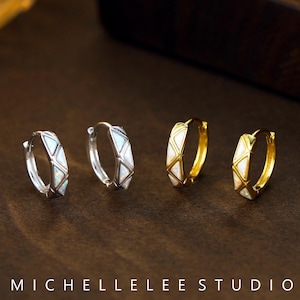 May include: A set of four hoop earrings with a geometric design. Two earrings are silver and two are gold. Each earring is decorated with white opal stones.