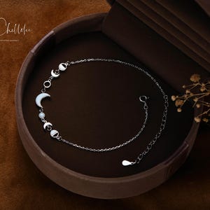 Peut inclure: Un bracelet en cha&icirc;ne argent avec un motif de lune et d'&eacute;toile. Le bracelet est dans une bo&icirc;te en velours marron.