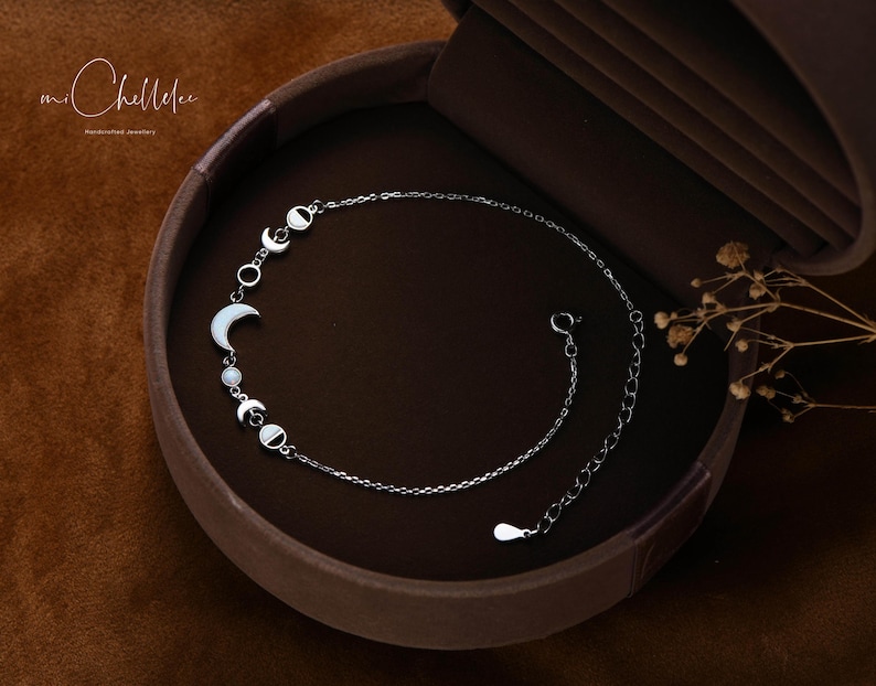 Peut inclure: Un bracelet en cha&icirc;ne argent avec un motif de lune et d'&eacute;toile. Le bracelet est dans une bo&icirc;te en velours marron.