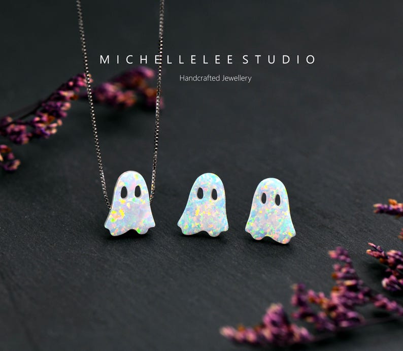 Pu&ograve; includere: Una collana e un paio di orecchini a lobo con pendenti a forma di fantasma in opale bianco con macchie iridescenti. La collana include una sottile catenina d'argento. Il testo MICHELLELEE STUDIO Handcrafted Jewellery &egrave; visibile in alto.