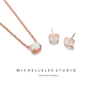 May include: A delicate rose gold necklace and matching earrings with oval-shaped white opal stones. The jewelry is handcrafted and features a simple chain design.