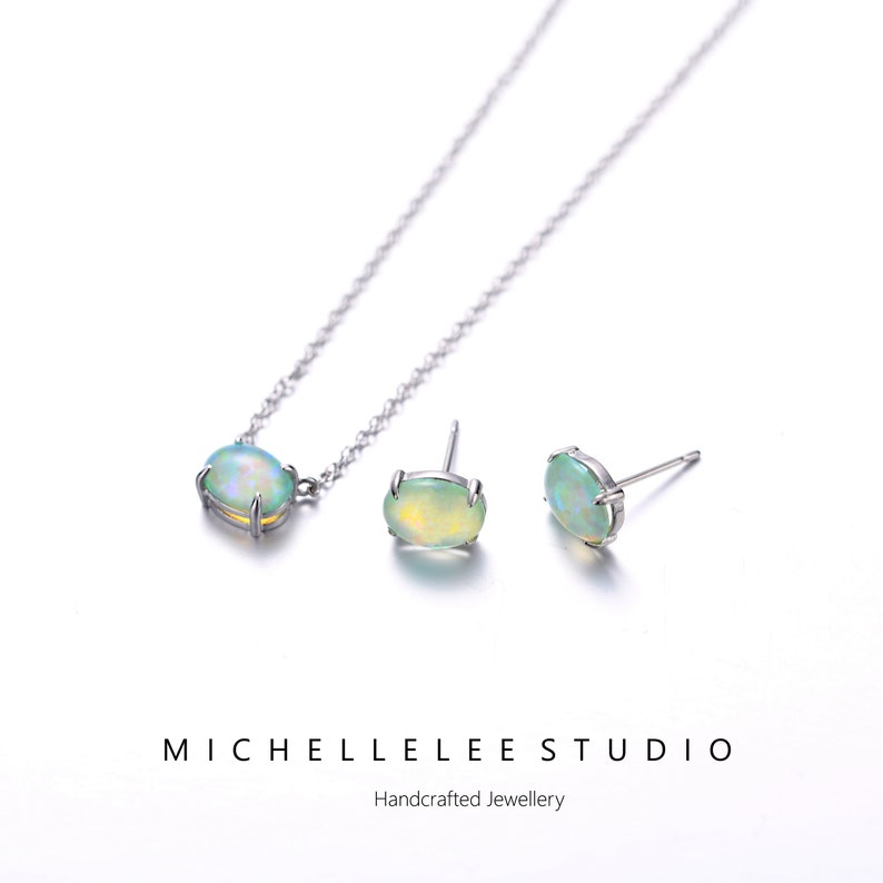 May include: A silver necklace and earrings set with a green opal gemstone. The necklace has a delicate chain and the earrings are stud style. The set is handcrafted and comes from Michelle Lee Studio.