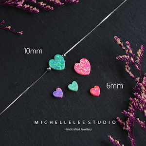 May include: A silver necklace with a 10mm green heart pendant and several smaller heart-shaped gemstones in shades of pink, green, and purple. The image includes the text "MICHELLELEE STUDIO Handcrafted Jewellery".