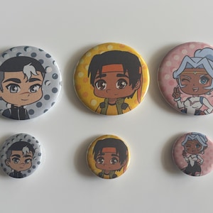May include: Six round pinback buttons with cartoon character illustrations. The buttons feature three different characters in various sizes. The largest buttons are approximately 2.25 inches in diameter, while the smallest are about 1 inch.