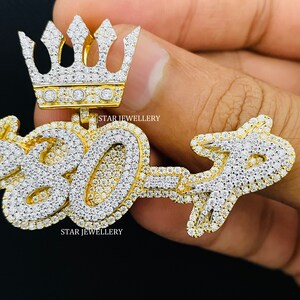 May include: Gold pendant with a crown on top and the numbers "807" set with diamonds. The pendant is held in a hand. The text "STAR JEWELLERY" appears twice on the pendant.