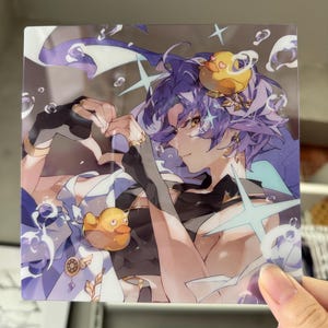 May include: Square print featuring an anime-style character with purple hair and a yellow rubber duck. The character is making a heart shape with their hands. The print has a light blue and white color scheme with star and bubble accents.