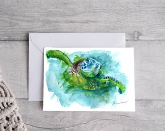 May include: Watercolor painting of a green sea turtle swimming in blue water. The turtle's head is turned to the side, and its shell is visible. The painting is on a white background.