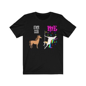 May include: Black t-shirt with a graphic featuring a brown horse labeled "Other CCOS" and a unicorn pole dancing labeled "Me". The unicorn has a rainbow mane and tail, with colorful stars around it.