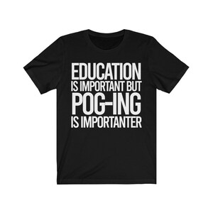 May include: Black t-shirt with white text. The text reads: "EDUCATION IS IMPORTANT BUT POG-ING IS IMPORTER." The shirt is made of a soft material and has short sleeves and a crew neck.