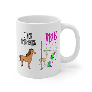 May include: White ceramic mug with a handle. The mug features the text "OTHER NEIGHBORS" and "ME" with illustrations of a horse and a unicorn pole dancing. The unicorn has a rainbow mane and tail. Colorful stars are scattered around the unicorn.