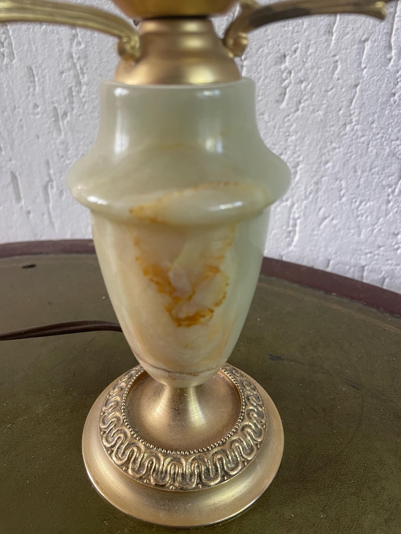 Op de afbeelding: Een groene en gouden tafellamp met een marmeren voet en een decoratieve gouden voet.