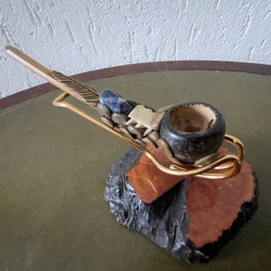 Small pipe in stand. Various types of wood, lapis lazuli and bone. Stand in wood with metal is of later date. Unique pipe smokers