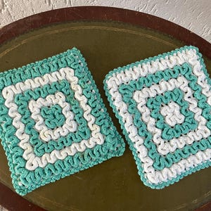 Set med 2 virkade gröna grytlappar. Praktiska i köket! De har aldrig använts, cirka 17x17 cm. Låga fraktkostnader.